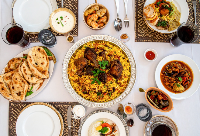 Eid-ul-Adha food table with traditional dishes like biryani, sheer khurma, dates, naan, fruit salad