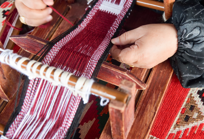 A woman makes a traditional sadu weaving