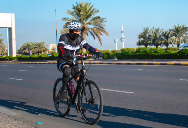 Cyclist riding bicycle on an empty street on the Arabian Gulf Road