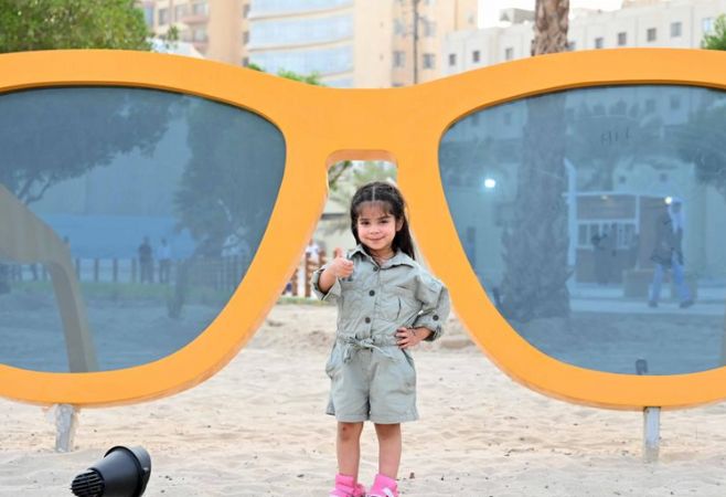 A girl poses for photos on Blajat Beach in Salmiya