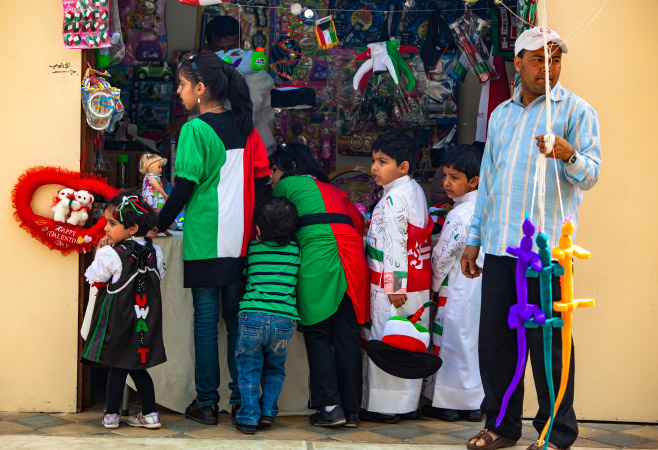 Children dressed in festive clothing in Kuwait City are celebrating their national pride